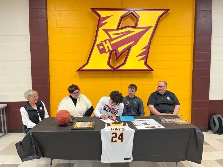 Hays High School Basketball standout Edwin Muller signs his National Letter of Intent to play at Hastings College on Tuesday, April 16, 2024.  (Photo courtesy of Angie Muller).